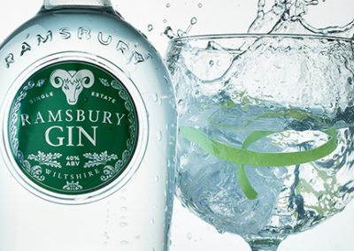 Close up of Ramsbury gin bottle and gin and tonic with a splash beside it.